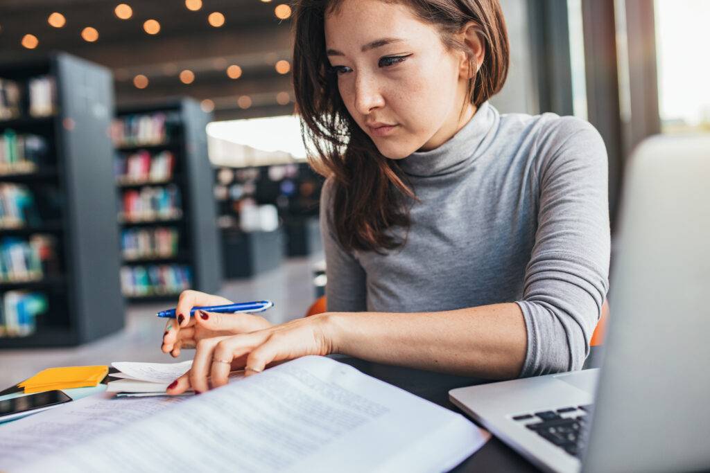 A young professional woman reviews business documents.