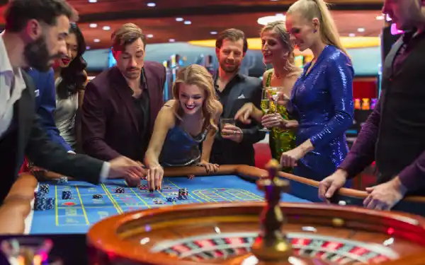 Friends gathered around a casino table gambling